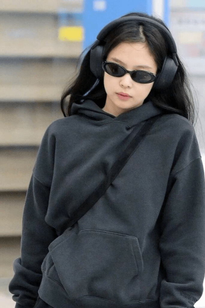 Jennie Kim signature airport accessories: Black Chanel mini bag and Gentle Monster sunglasses.