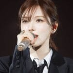 Red Velvet Wendy singing passionately into a stand mic during a live solo concert